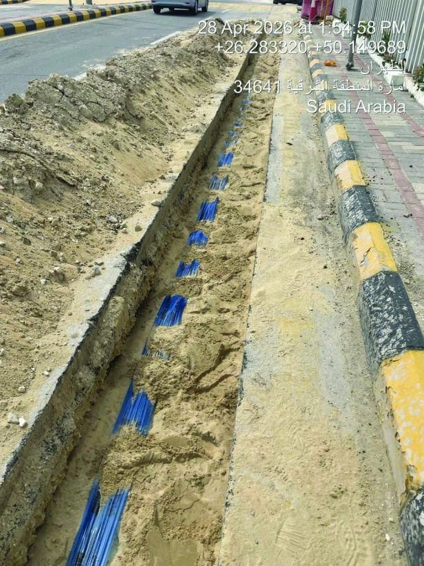 أنبوب مرافق أزرق ممدود داخل خندق محفور بالموقع