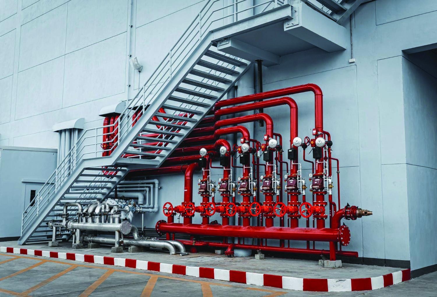 Fire protection pipe network installed along an industrial building